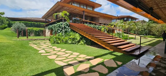 Casa no Haras Larissa com estrutura em madeira, jardim e escada externa