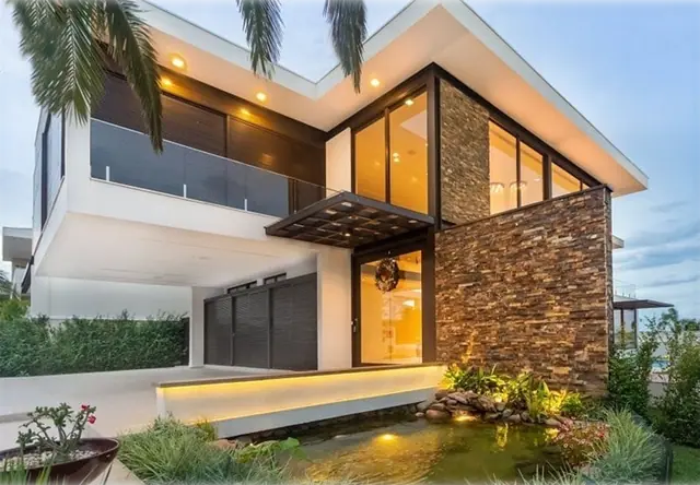 Casa moderna entregue no Mont Blanc, com revestimento em pedra e iluminação de fachada